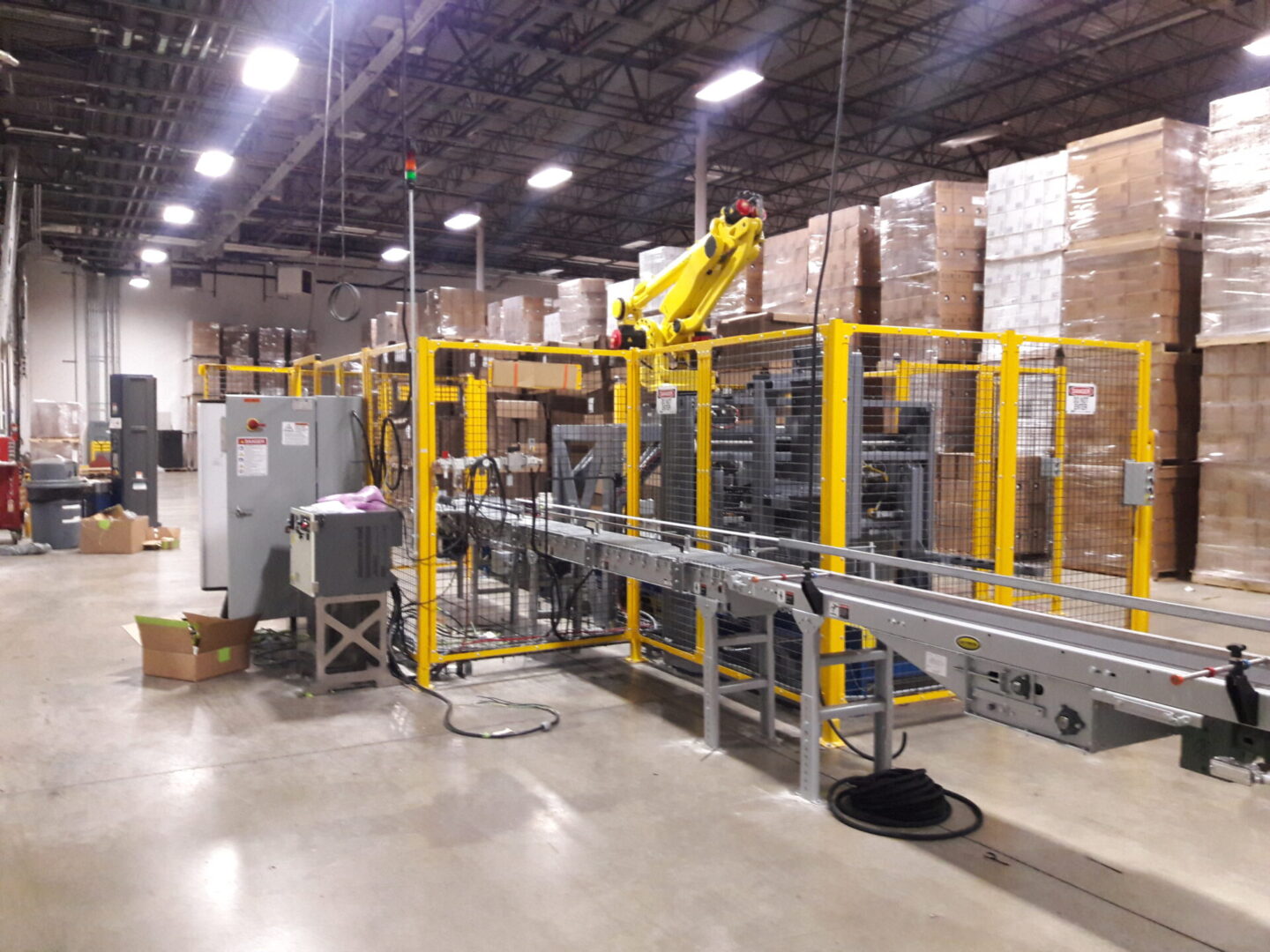 A warehouse with boxes on the floor and a conveyor belt.