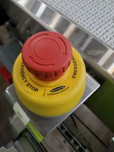 A red and yellow button on top of a yellow object.